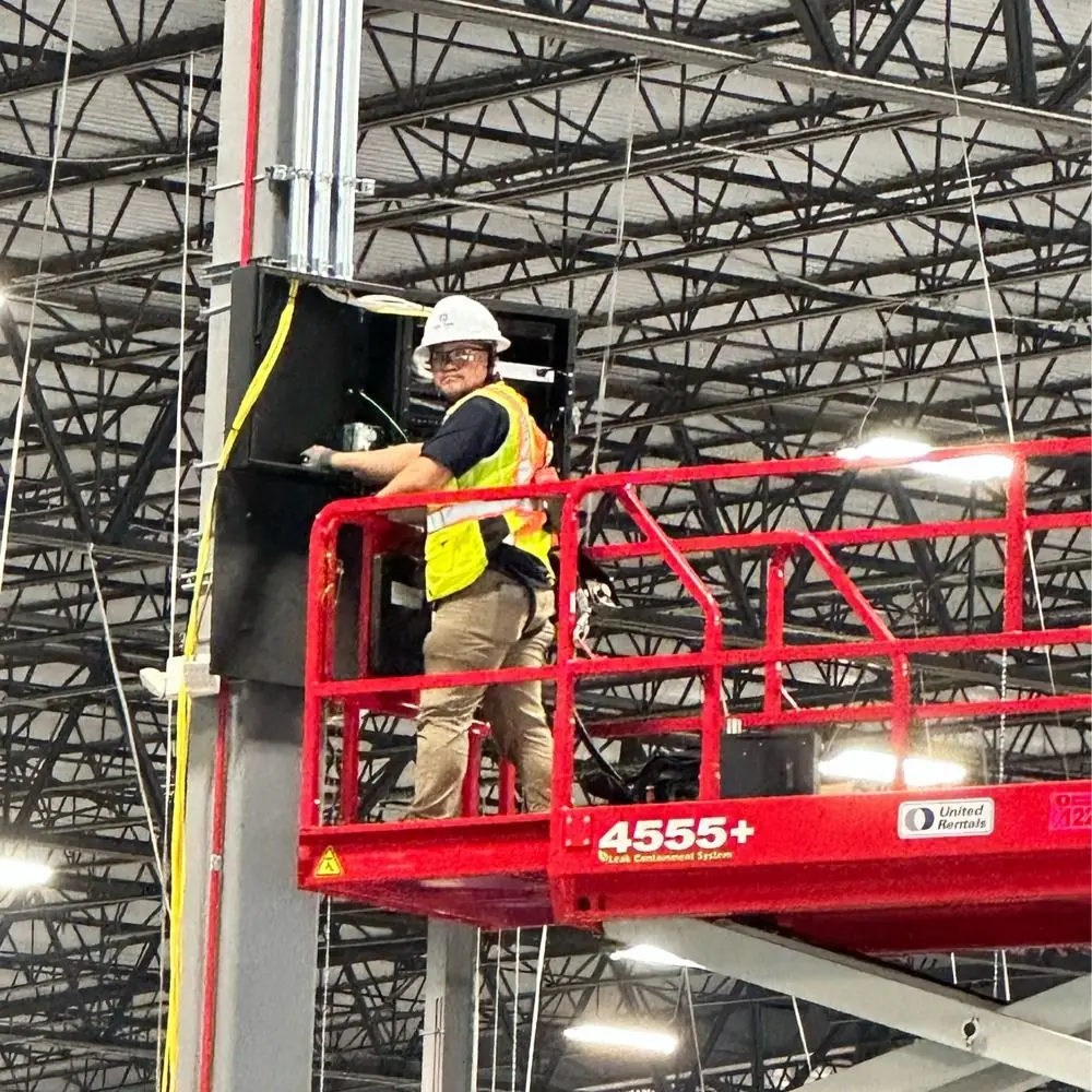 United Security technician on a lift wiring cameras in a warehouse